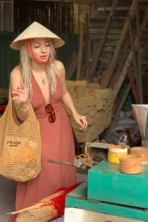 A traveler learning how to make incense sticks with local experts in Hanoi.