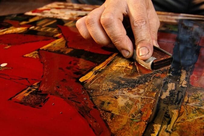 Close-up of meticulous craftsmanship at Ha Thai traditional lacquerware craft village.
