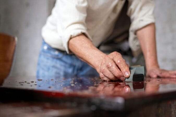 Experienced artisans decorate lacquerware during a tour of traditional crafts in Hanoi.