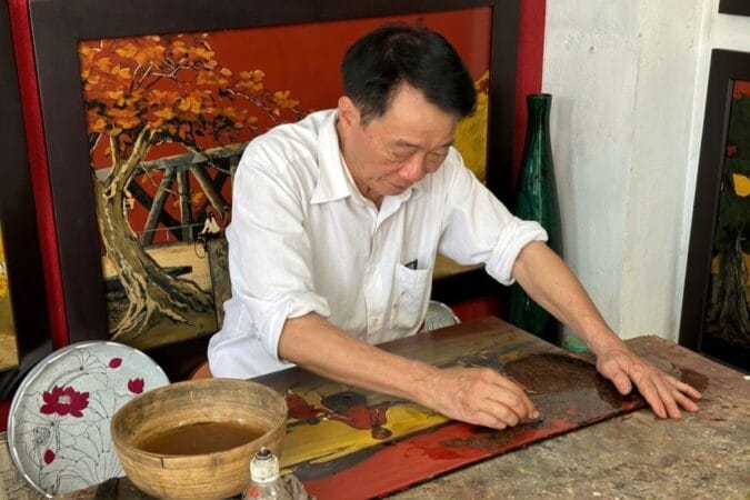 The authentic craftsmanship of Ha Thai lacquerware makers in their traditional workshop.